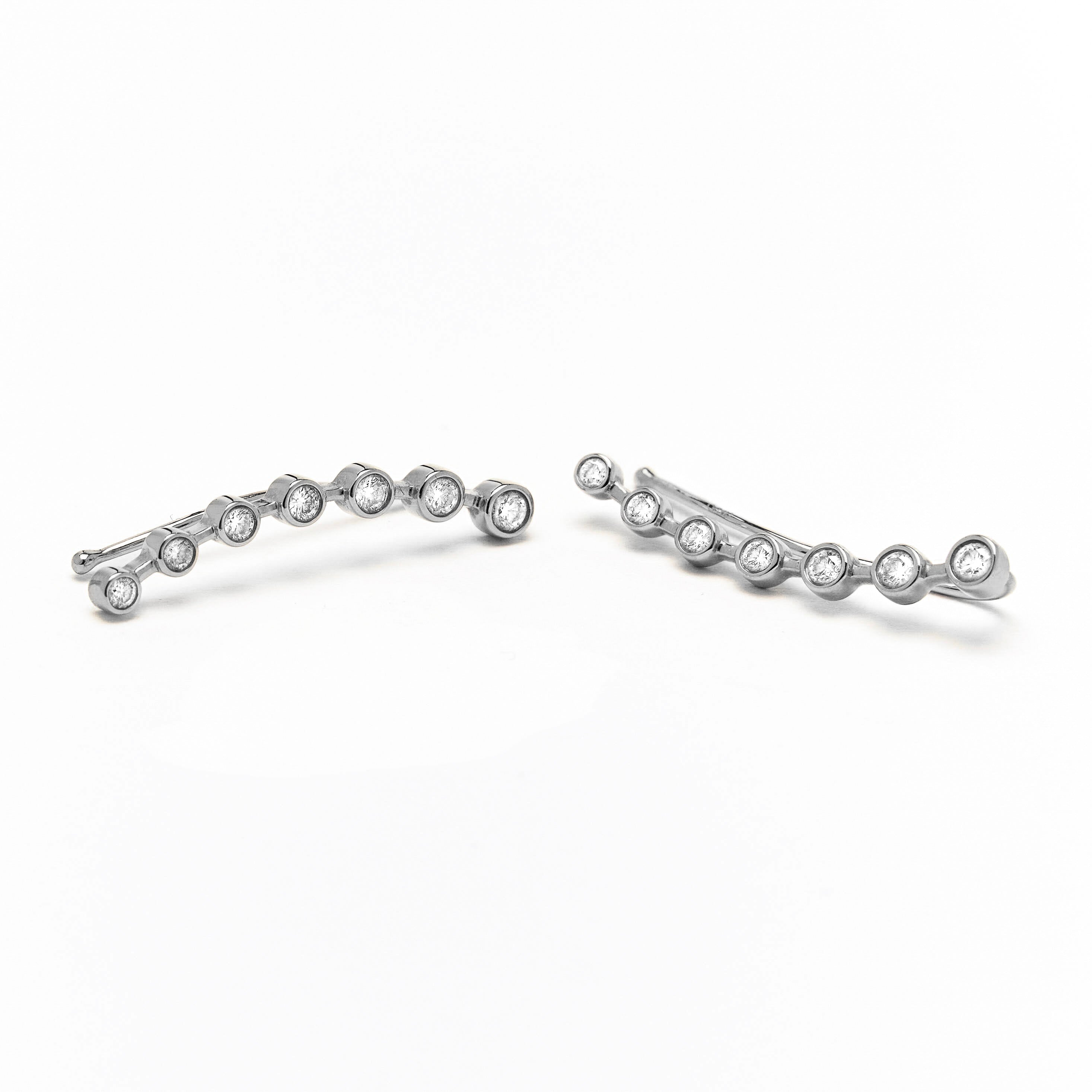 gold ear-crawler earrings adorned with white diamonds.