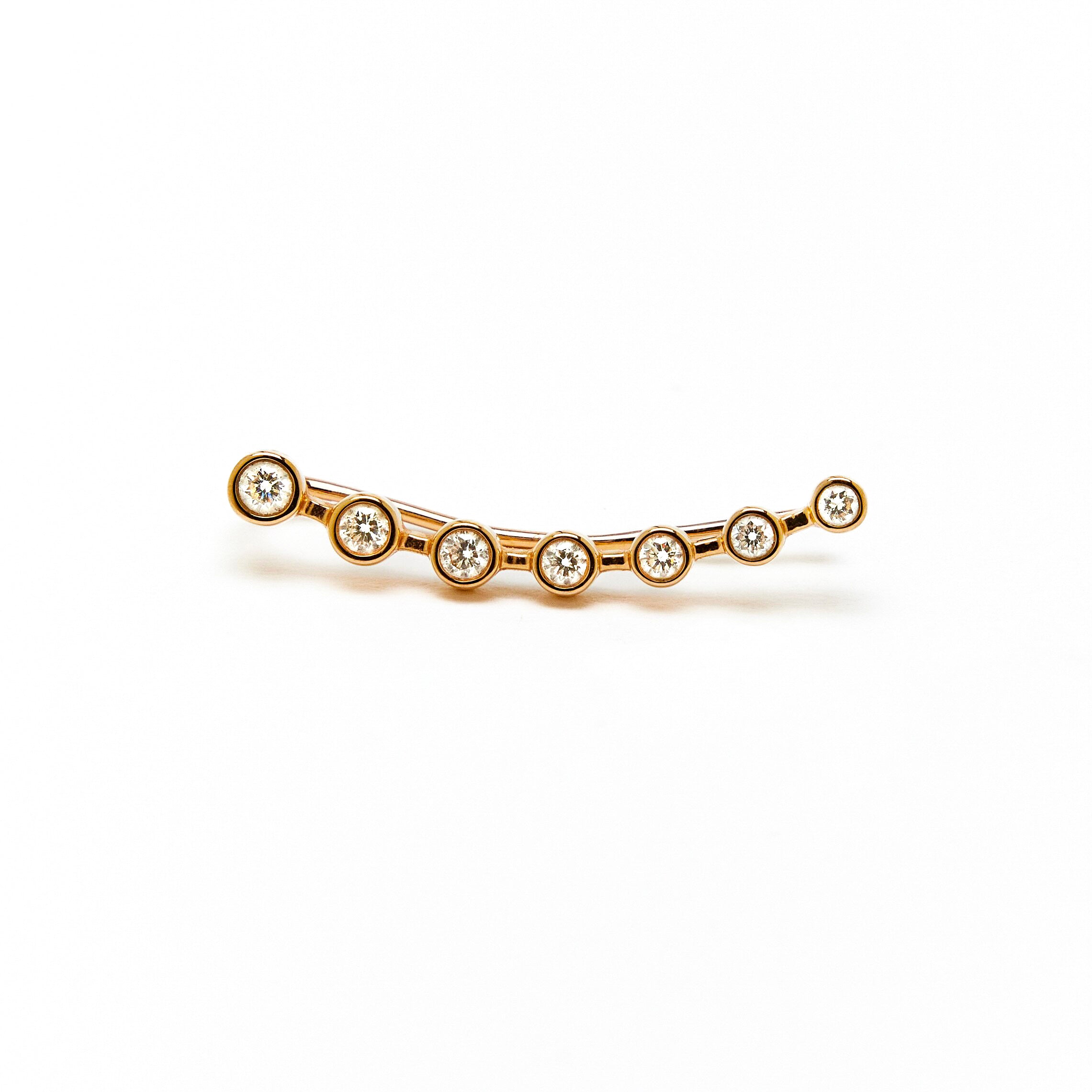a gold ear-crawler earring adorned with white diamonds.