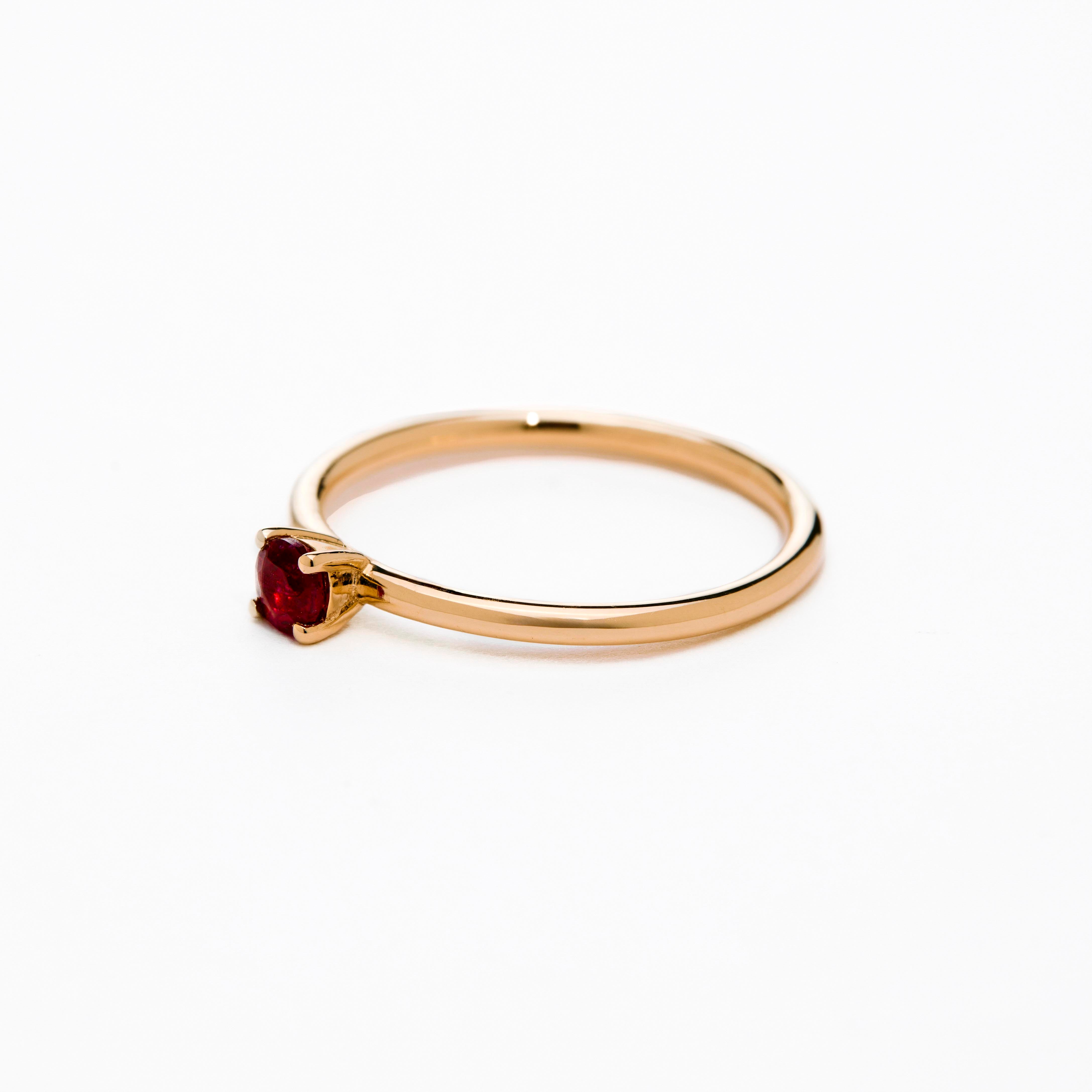 gold ring with a small cute ruby on a a white background. 