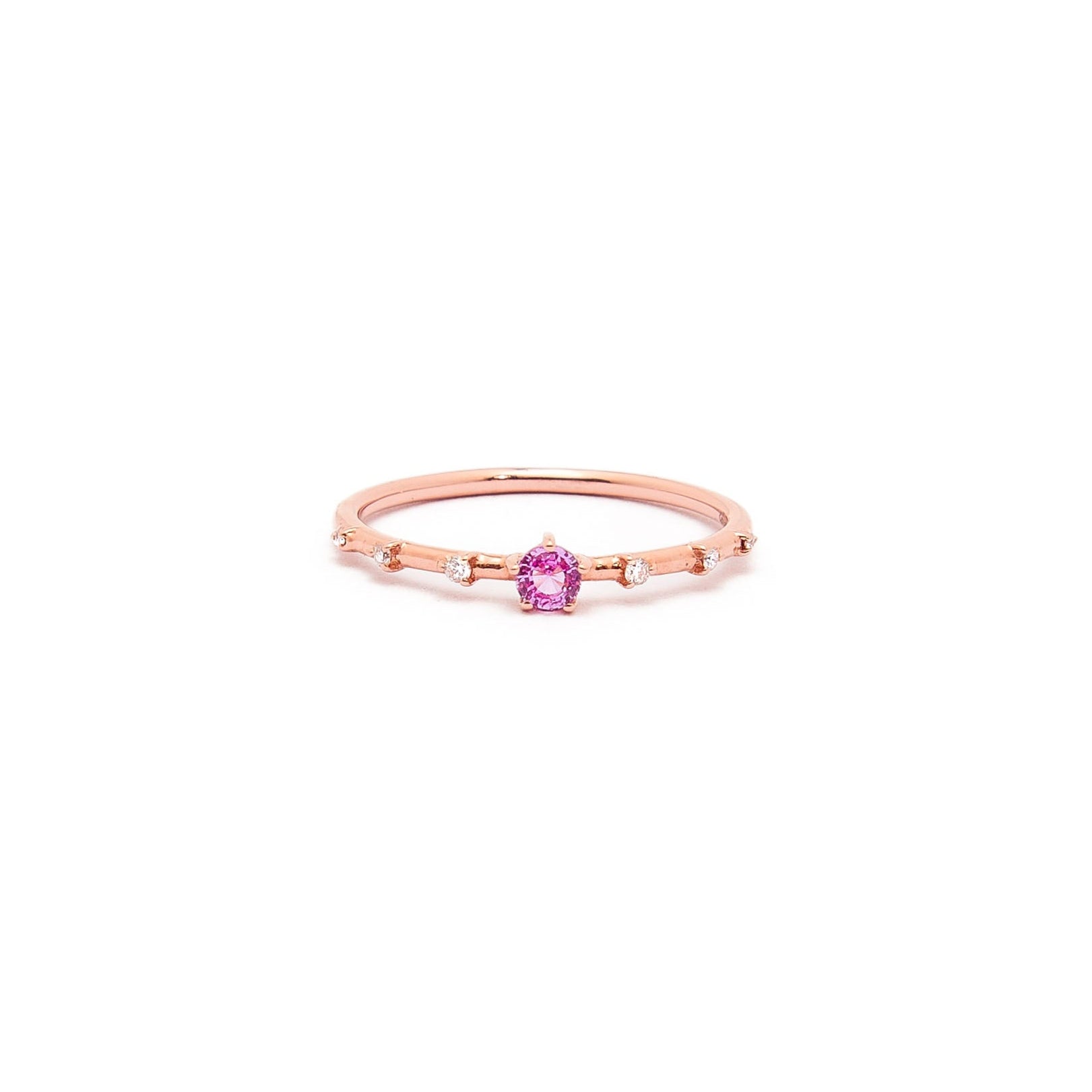 A gold band ring featuring a central sapphire with smaller diamond accents around it, presented against a white background.