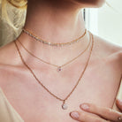 Close-up of a person wearing multiple necklaces with a blurred background