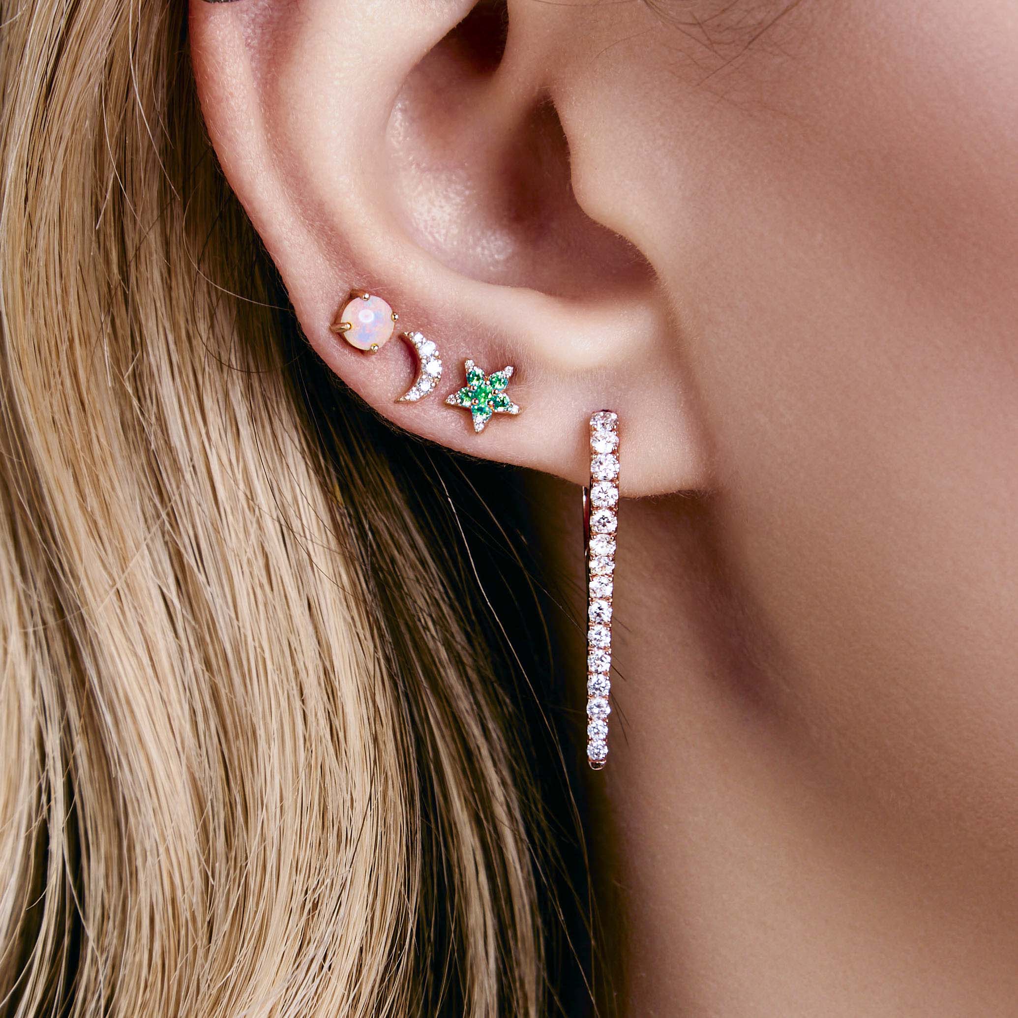 australian opal dot earrings, diamonds moon earrings, emerald and diamonds star earrings, icicle diamonds drop earrings on a model's ear