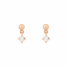 Rose gold earrings with round diamonds on a white background
