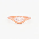 Rose gold solitaire ring with a marquise diamond on a white background.