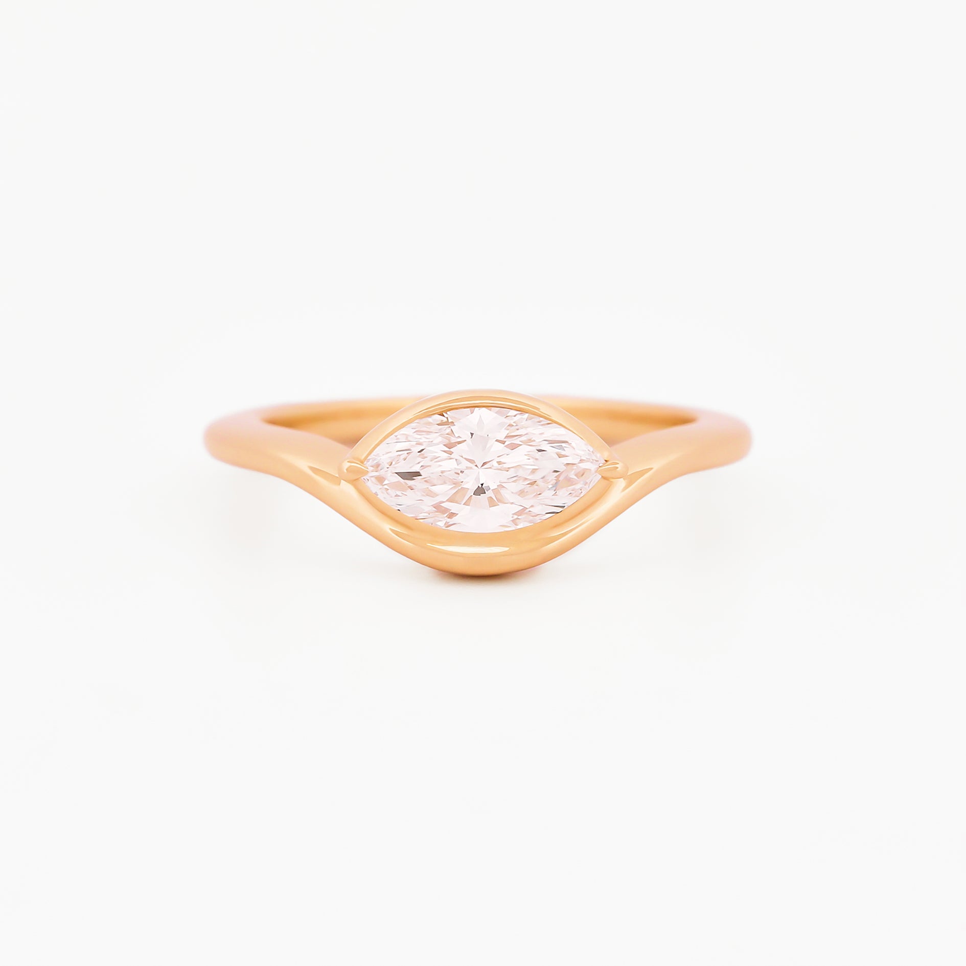 Yellow gold solitaire ring with a marquise diamond on a white background.