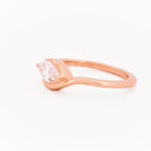 Rose gold solitaire ring with a marquise diamond on a white background