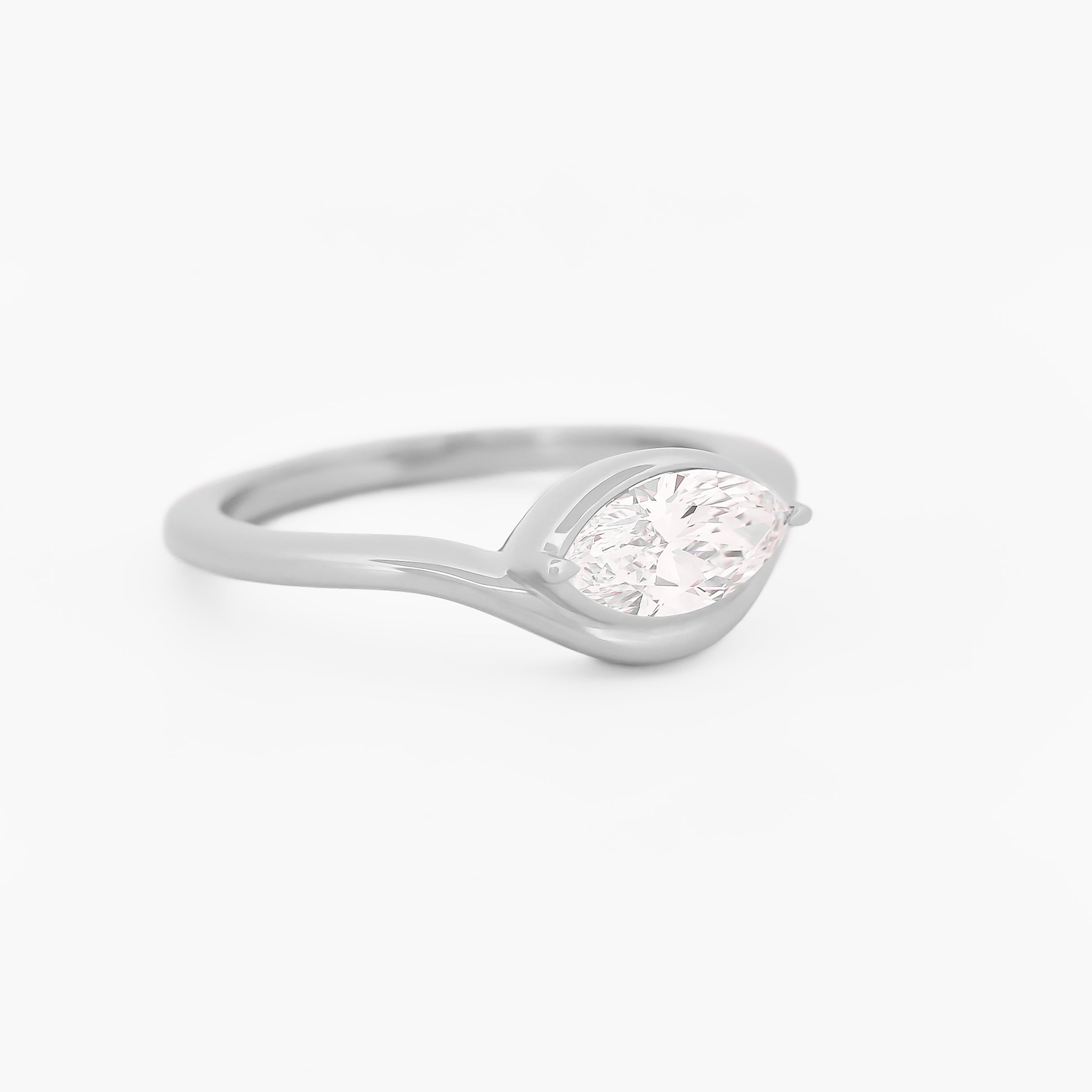 white gold solitaire ring with a marquise diamond on a white background