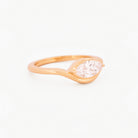 Yellow gold solitaire ring with a marquise diamond on a white background