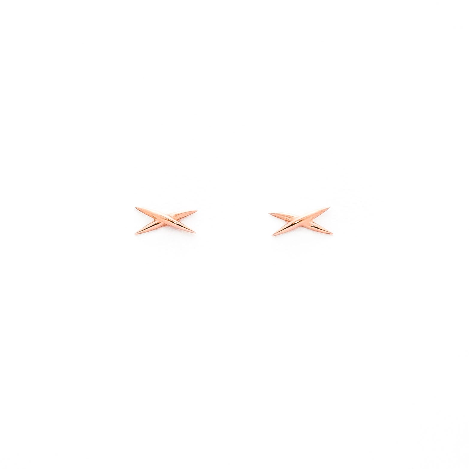 A pair of gold-colored stud earrings shaped like an X on a white background.