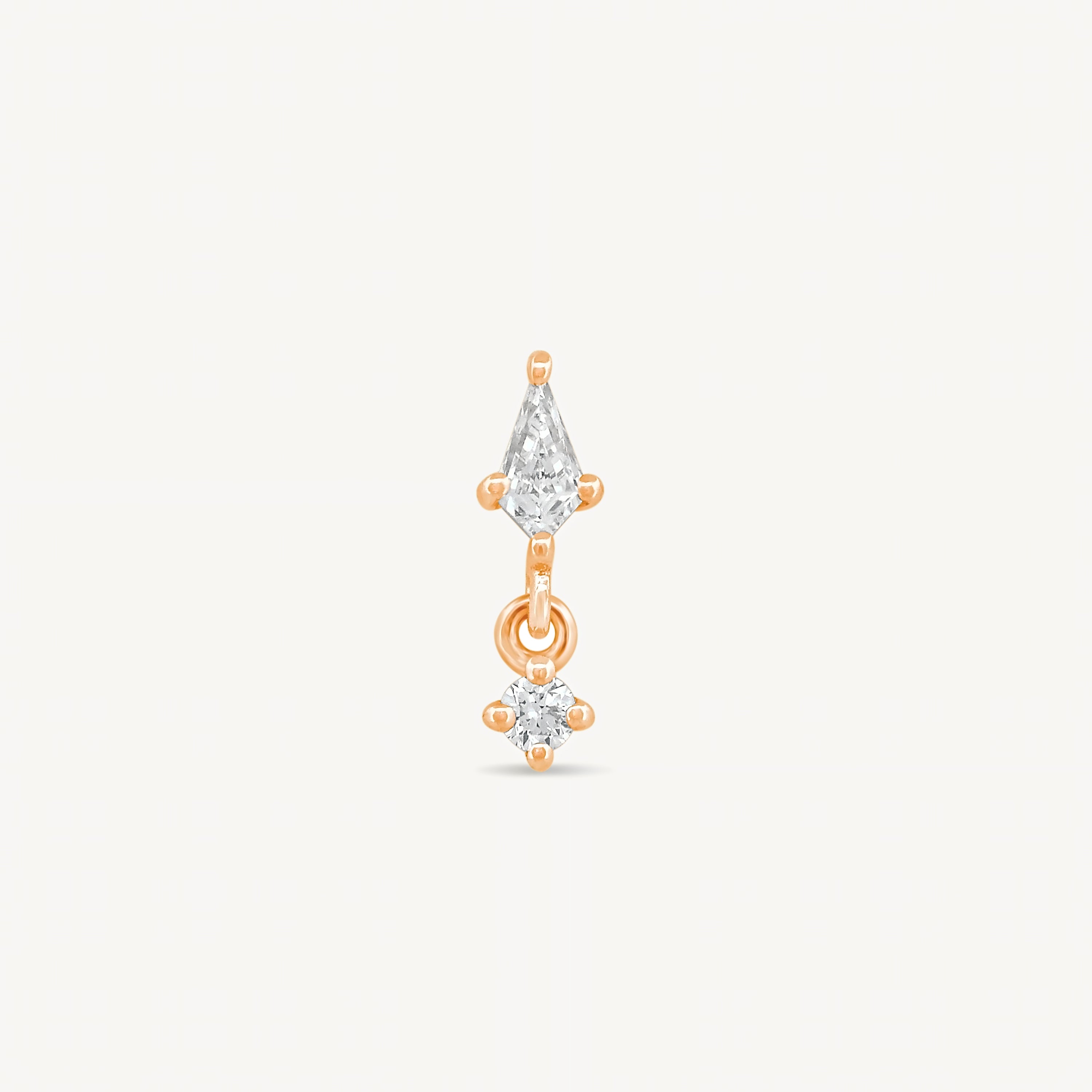 Kite and round diamonds stud earring with rose gold on a light gray background.