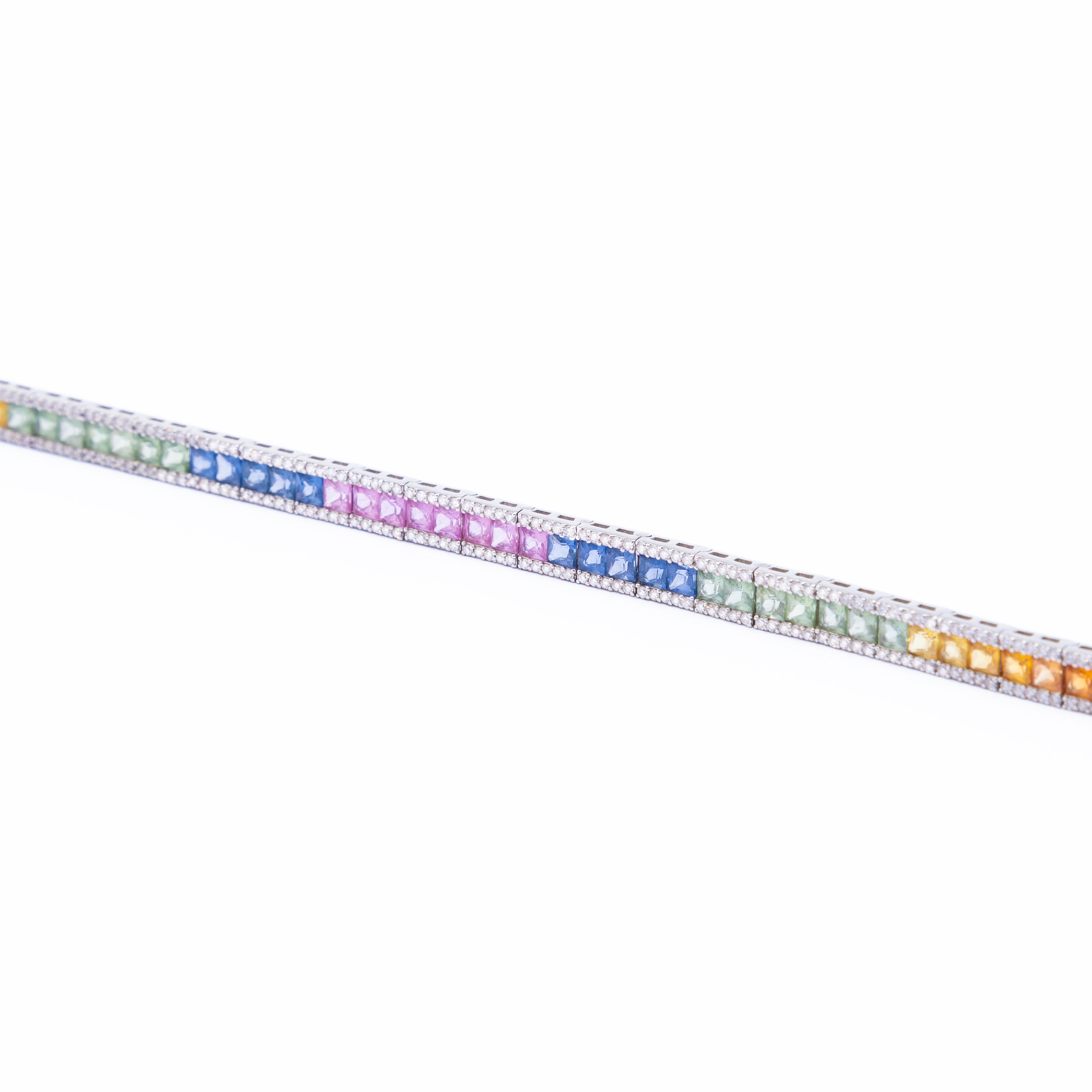 a tennis bracelet with rainbow sapphires and diamonds in 18k gold.