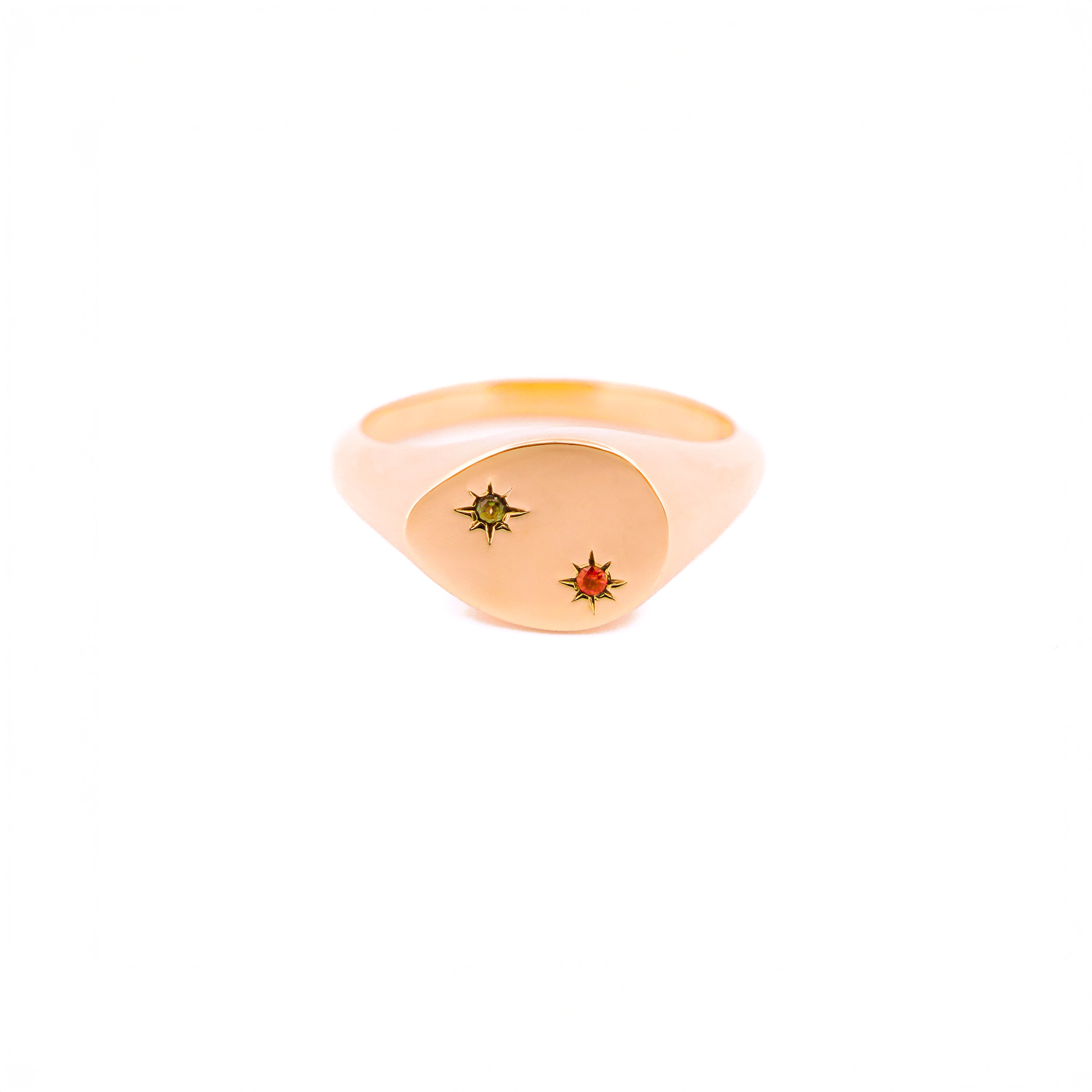 Gold signet ring with embedded gemstones on a white background, the stones are set inside 2 stars