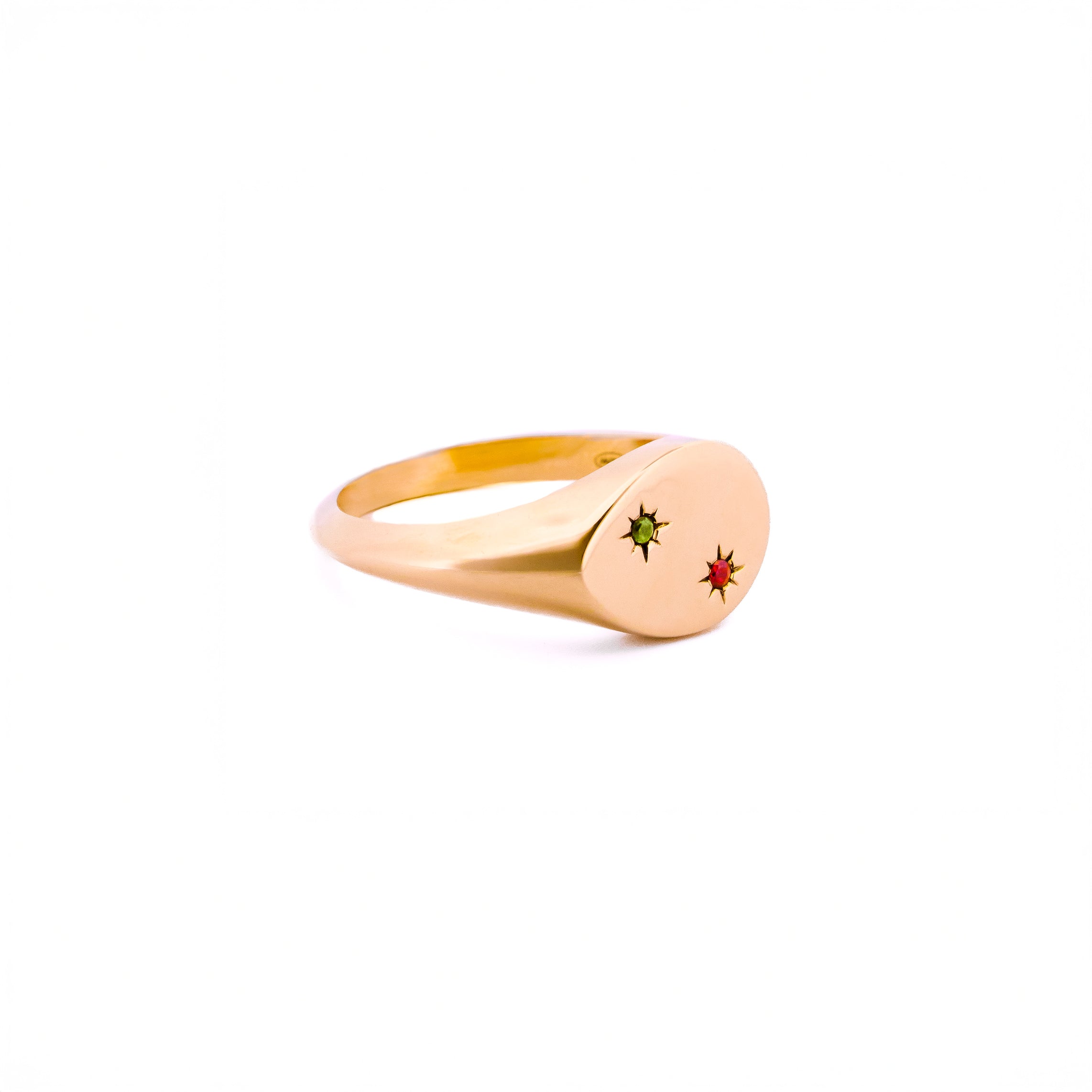 Gold signet ring with embedded gemstones on a white background, the stones are set inside 2 stars