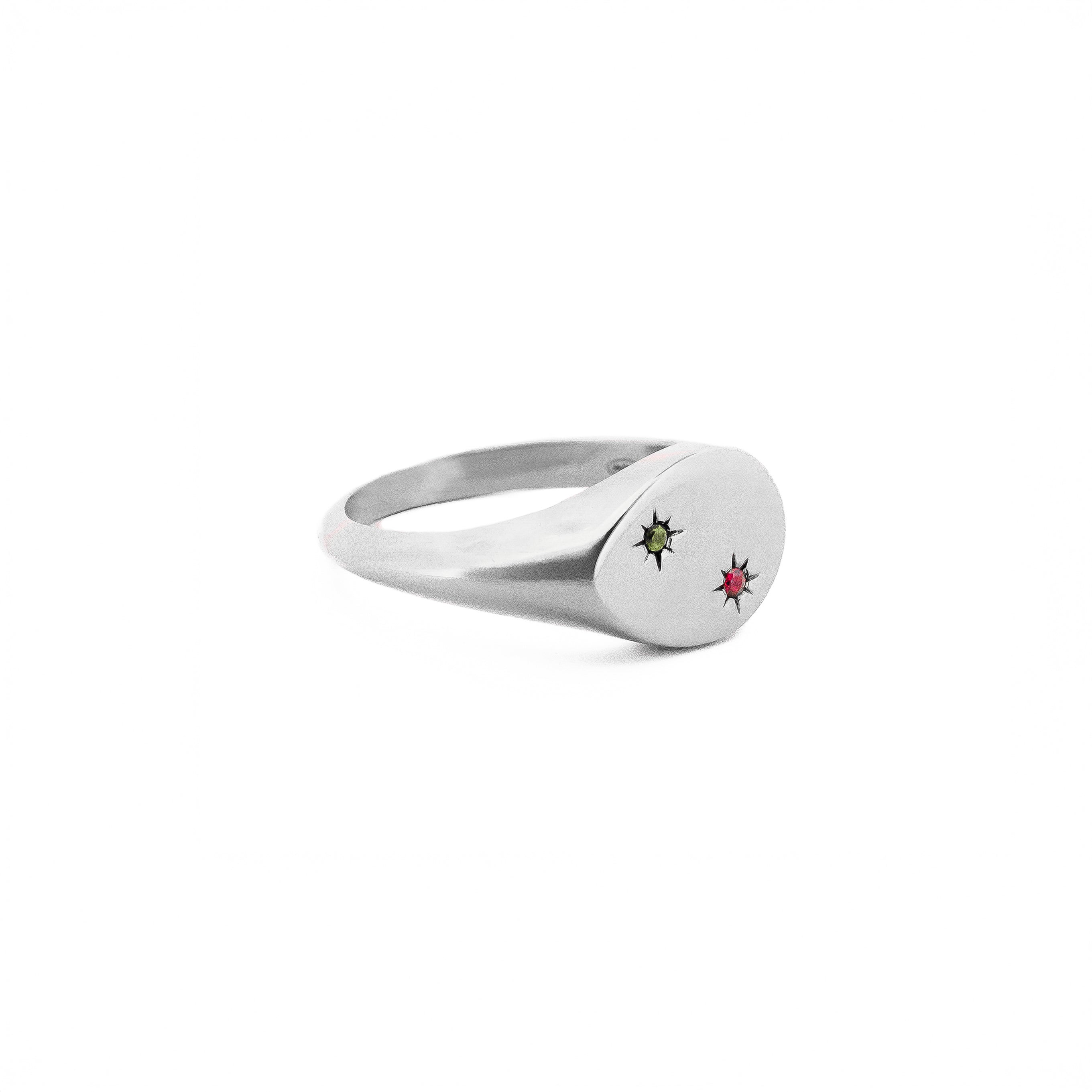 Gold signet ring with embedded gemstones on a white background, the stones are set inside 2 stars