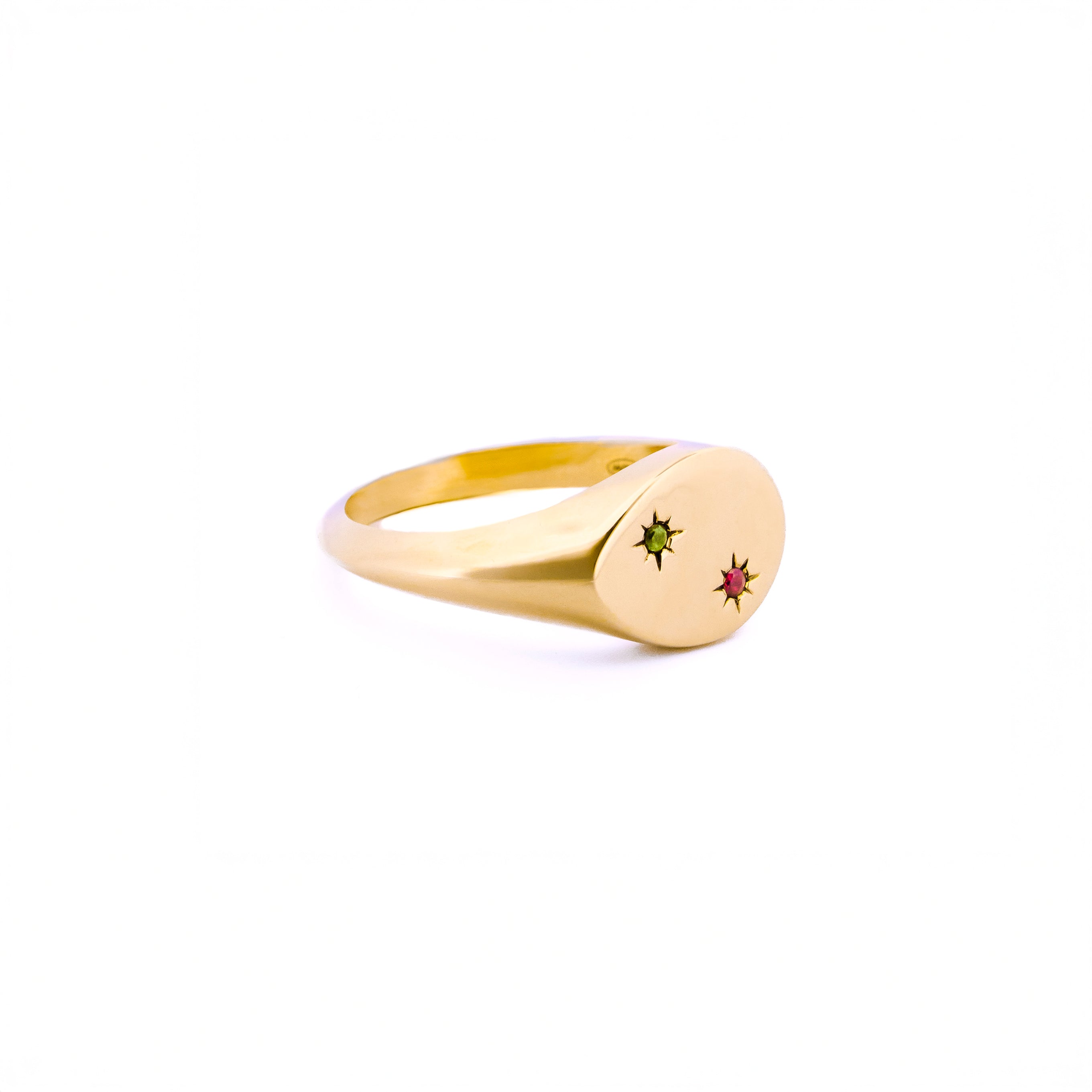 Gold signet ring with embedded gemstones on a white background, the stones are set inside 2 stars