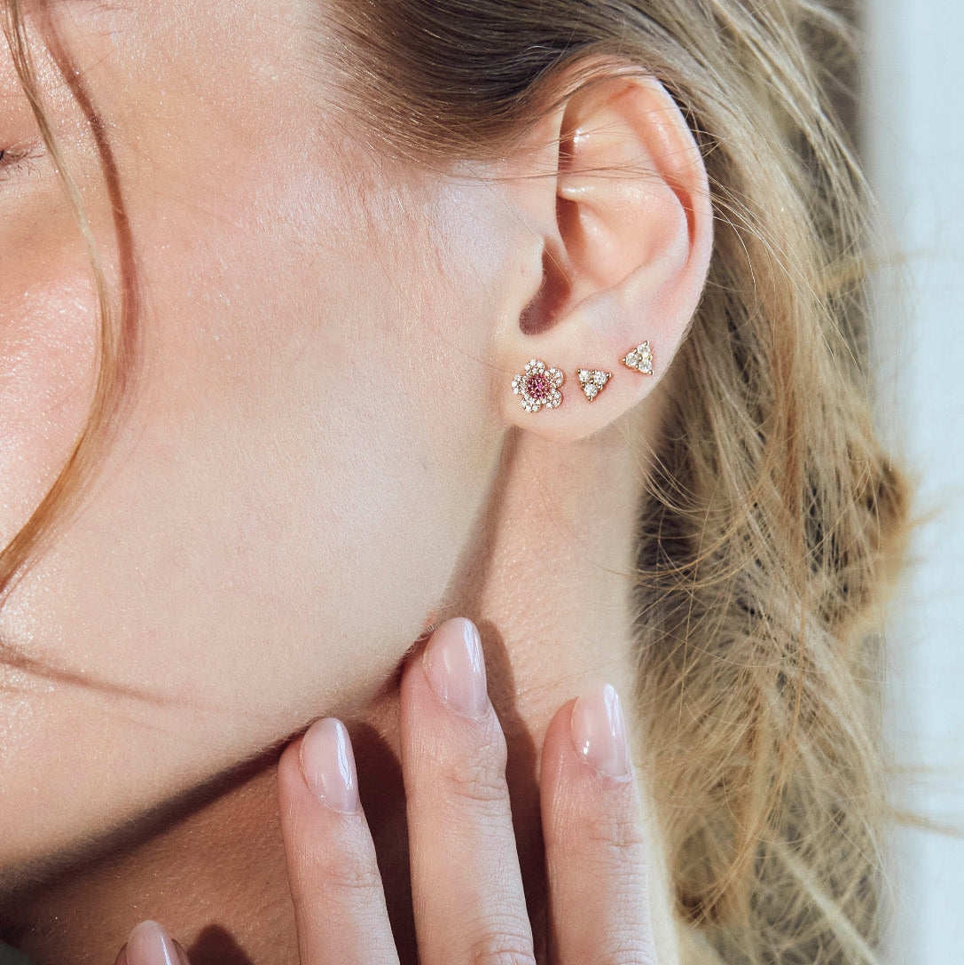 beautiful blossom flower earrings on model, diamond earrings simple arranged in a game of three dots.