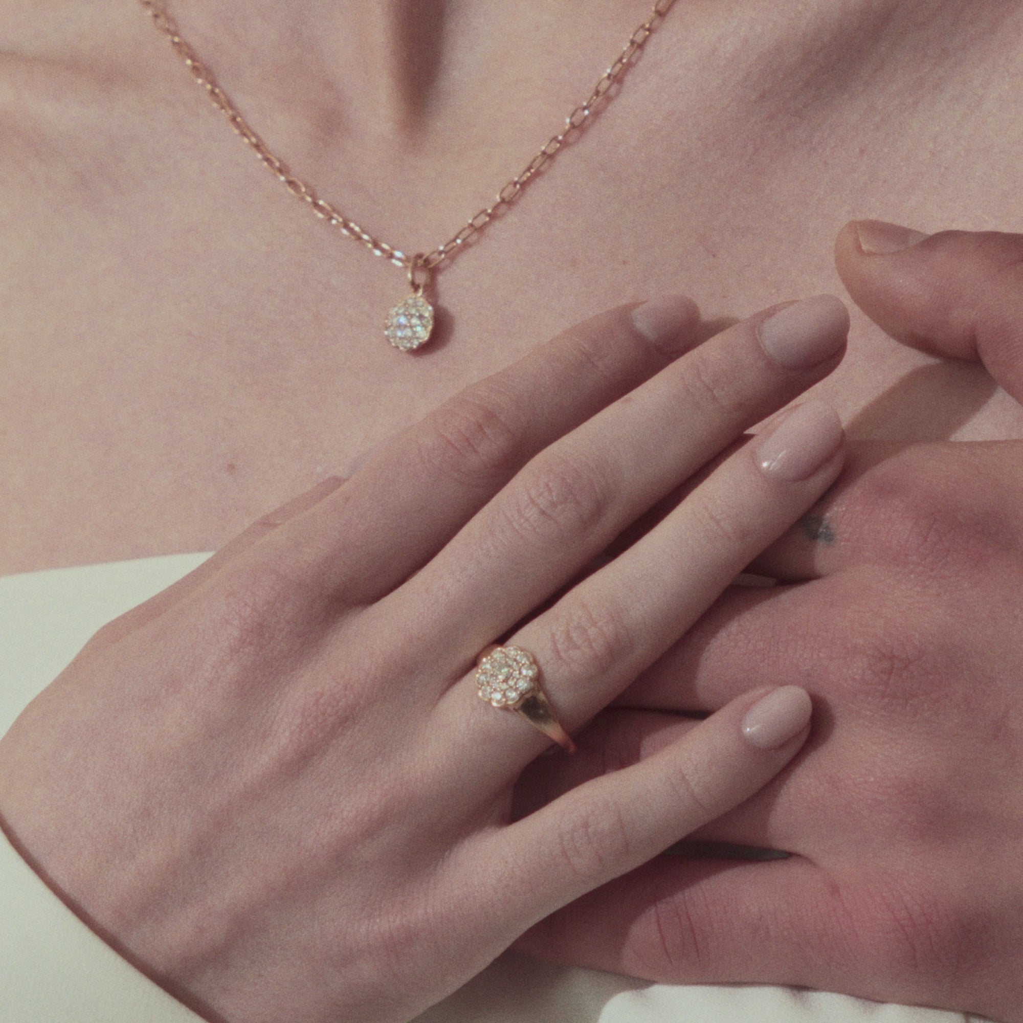 Rose gold ring with diamond cluster daisy flower on a hand
