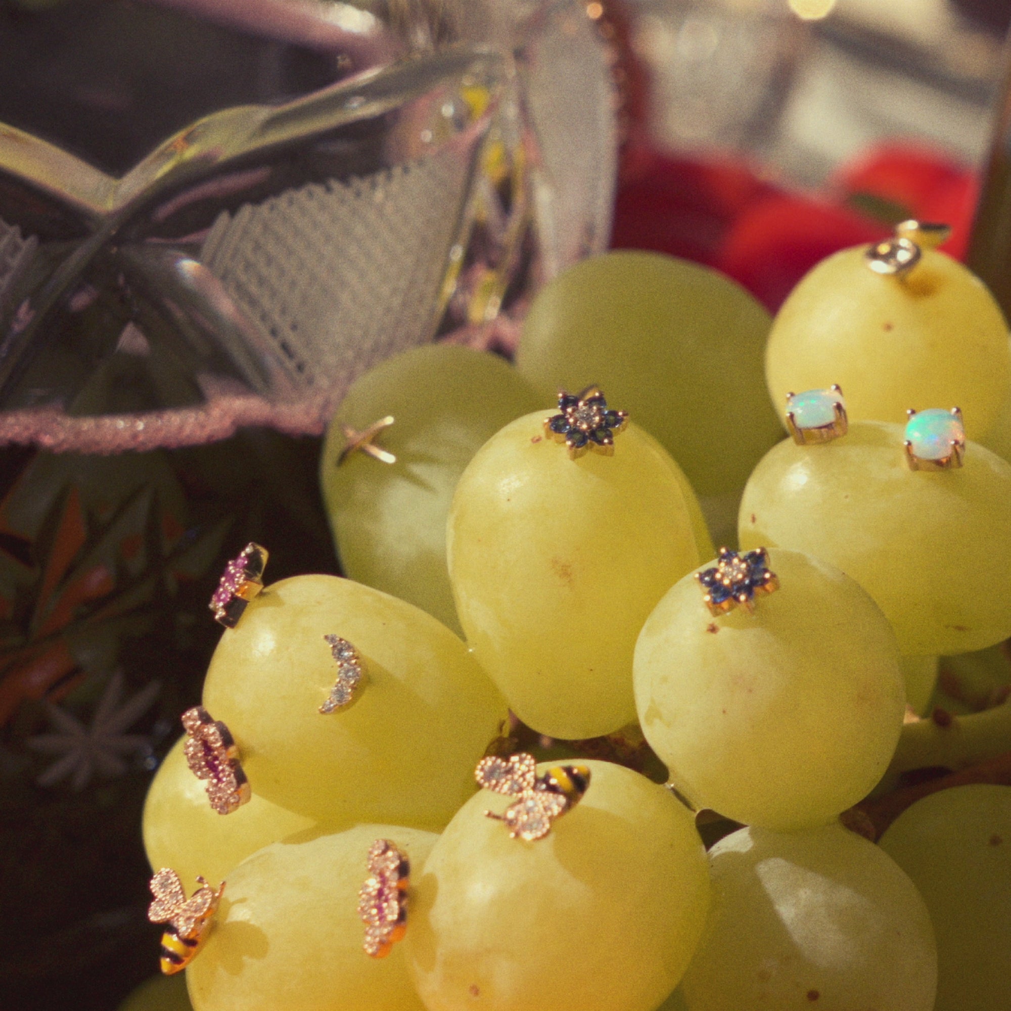 Amazing natural gemstones and diamonds earrings set in a bunch of green fresh grapes