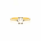 Ring with a large central rose-cut diamond and smaller side diamonds on a yellow gold band against a white background