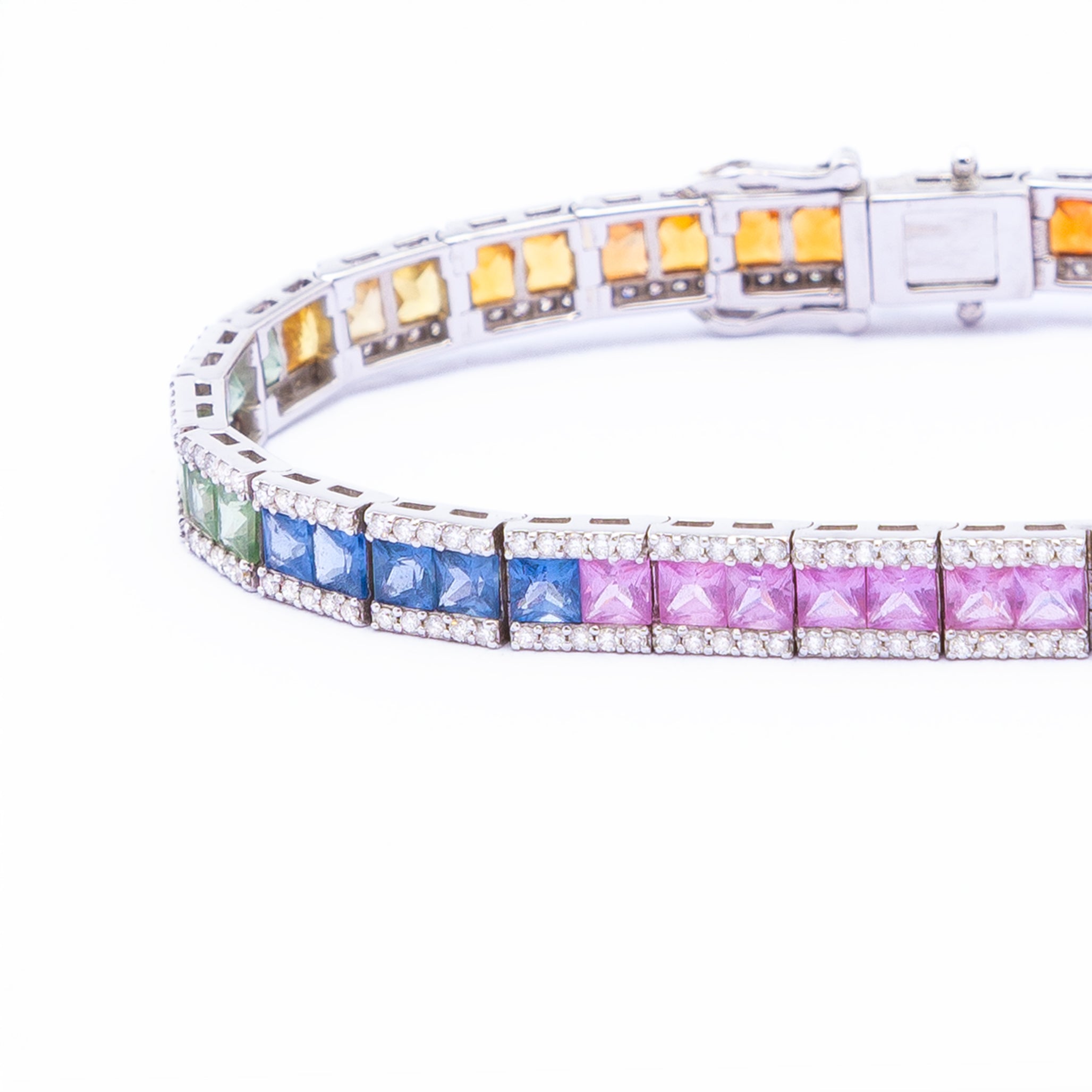 a tennis bracelet with rainbow sapphires and diamonds in 18k gold.